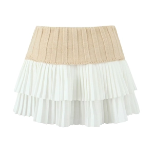 Detailed view of the layered pleated design and knit texture of this two-tone mini skirt