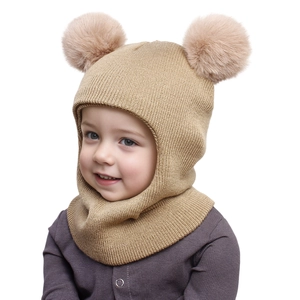 Close-up detail of khaki knitted kids balaclava with warm faux fur double pom-poms