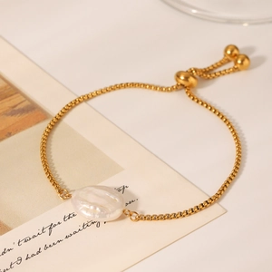 Detail of adjustable gold box chain bracelet with a lustrous white baroque pearl charm