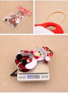Detail of fabric snowman ornament with beaded tassels showing weight on a scale