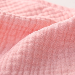 Close-up of soft pink double-layer cotton muslin fabric with a fine woven texture
