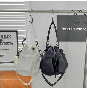 Detailed view of cream and black nylon drawstring bucket bags with adjustable straps