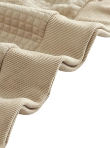 Nahaufnahme von khakifarbenem Waffelstrick und Rippbündchen am Sweatshirt mit Reißverschluss