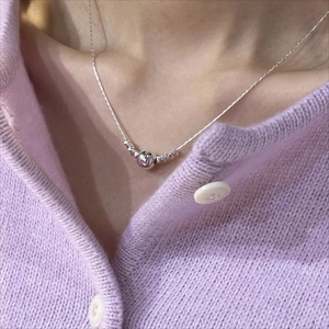 Minimalist 925 sterling silver bead pendant necklace worn on a light purple knit cardigan