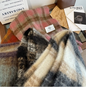 Close-up of soft plaid scarves with fringe details in pink, beige, and black colors
