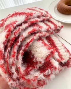 Close-up of the red and white striped wool scarf showing soft knit texture and fiber detail