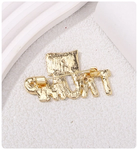 Close-up of golden Trump brooch with crown detail on a textured white surface