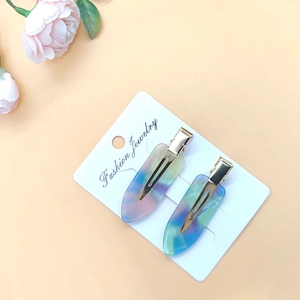 Rainbow acetate resin hair clips with gold metal base displayed on fashion jewelry card