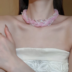 Detail of pink hand-woven beaded necklace with pearls and lace-style layers