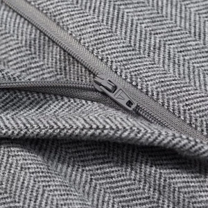Gros plan sur la fermeture éclair du gilet en maille grise avec motif à chevrons
