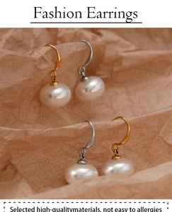 Detailed view of elegant pearl drop earrings with polished gold and silver metal hooks