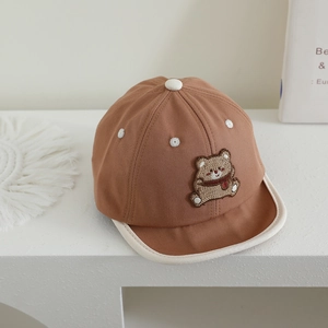 Detail of baby bear embroidered baseball cap with white piping and cotton twill texture