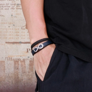 Detail of layered leather bracelet with silver infinity symbol and magnetic buckle