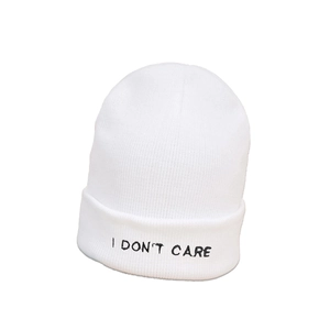 Detail of white beanie with black I DON'T CARE embroidery and fine knit texture