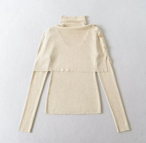Detail of knit sweater set with turtleneck poncho featuring golden buttons on shoulders