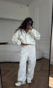 Détail d'un ensemble en tricot gris deux pièces avec cardigan zippé et pantalon large