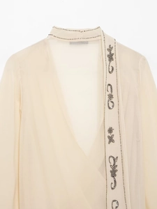 Detail of hand-beaded sequins and floral embroidery on a sheer georgette blouse
