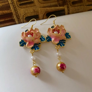 Details von Emaille-Blumenohrringen mit weißen Perlen und bedruckten Goldperlen