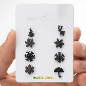 Detail of four pairs of black stainless steel Christmas studs including reindeer and snowflake