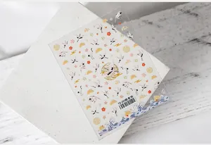 Macro detail of 5D nail stickers featuring cranes and clouds on textured stone