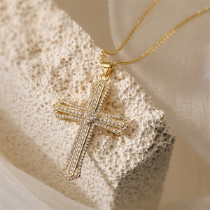 Nahaufnahme eines doppellagigen 18K Gold-Kreuzanhängers mit Mikropavé-Zirkonia Kristallen
