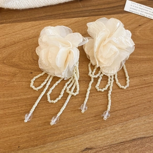 Detail view of chiffon flower earrings with elegant bead tassels and waterdrop pendants