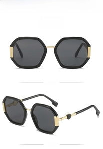 Detail of geometric octagonal sunglasses featuring gold spherical metal accents on temples