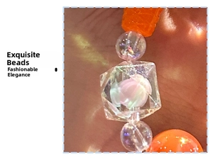 Detail of beaded keychain with faceted orange and transparent acrylic resin beads