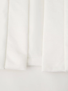 Detail of white padded vest showing textured fabric and high-quality hem craftsmanship