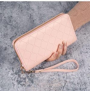 Detailansicht der rosa langen Geldbörse mit geometrischer Prägung und Handschlaufe