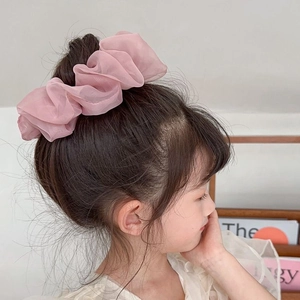 Pink oversized chiffon scrunchie shown on a high bun hairstyle for a sweet look