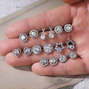 Detail shot of silver stud earrings set featuring zircons in flower and heart shapes
