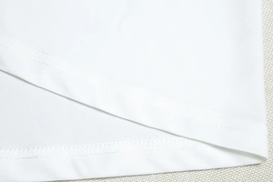 Close-up of professional double-needle stitching on white sleeveless halter maxi dress