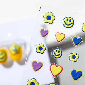 3D embossed nail art stickers with colorful flowers and smiley faces on clear backing