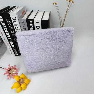 Detail of lavender plush cosmetic bag with soft faux fur texture and zipper closure