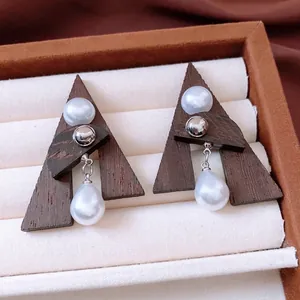 Retro triangle wood earrings with pearl accents and silver pins in a jewelry box