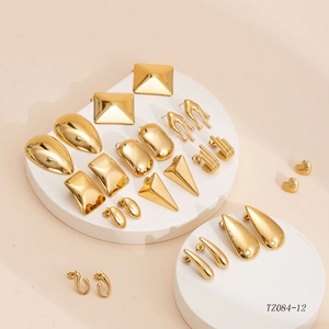 Polished gold geometric earrings set with various shapes on a minimalist white display