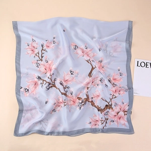 Detail of silk scarf showing pink magnolia prints on a soft blue and purple background