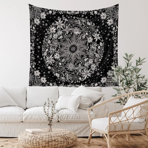 Vista dettagliata di un arazzo bohémien nero con motivi mandala bianchi sulla parete di casa