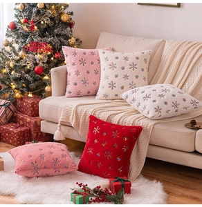 Close-up of festive plush pillow covers with colorful embroidered snowflake patterns