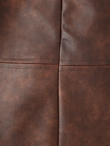 Gros plan détaillé de la texture en similicuir marron et des coutures de la veste