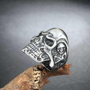 Macro shot of vintage skull ring with antique finish on weathered wood background
