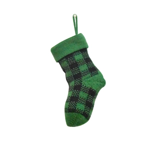 Detail of green and black plaid knitted Christmas stocking with hanging loop on white background