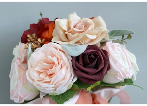 Detail of silk bridal bouquet featuring champagne roses and peonies with elegant pink ribbons