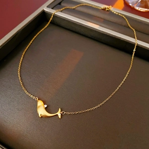 Macro shot of gold whale pendant with zircon eye in a premium jewelry box