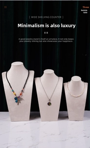 Three beige velvet necklace bust displays in small medium and large on marble surface