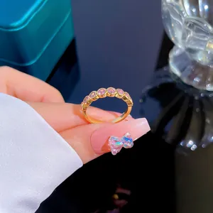 Detail view of gold ring with seven inlaid pink-purple round zircons on a jewelry box