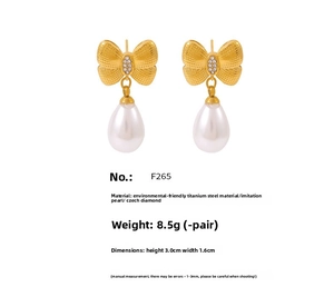 Detail of gold bowknot earrings with pearls and rhinestones showing 3.0cm size and weight
