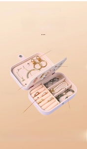 Inside view of a pink double-layer portable jewelry box with functional compartments