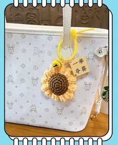 Crochet sunflower keychain with first prize tag hanging on a stylish white tote bag.